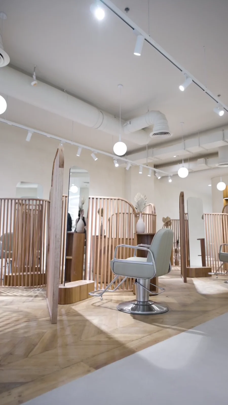 A styling chair and curved timber screens inside KOOP Manila